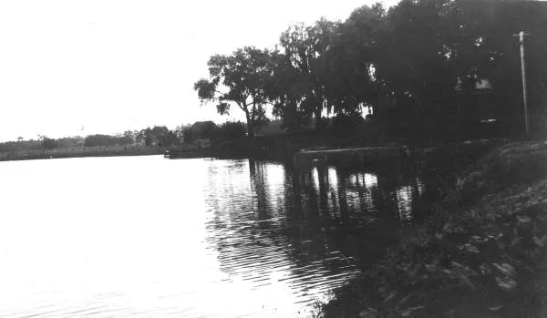Black-and-white photograph of Lake Cherokee in 1915, looking across calm water at a wooded shoreline